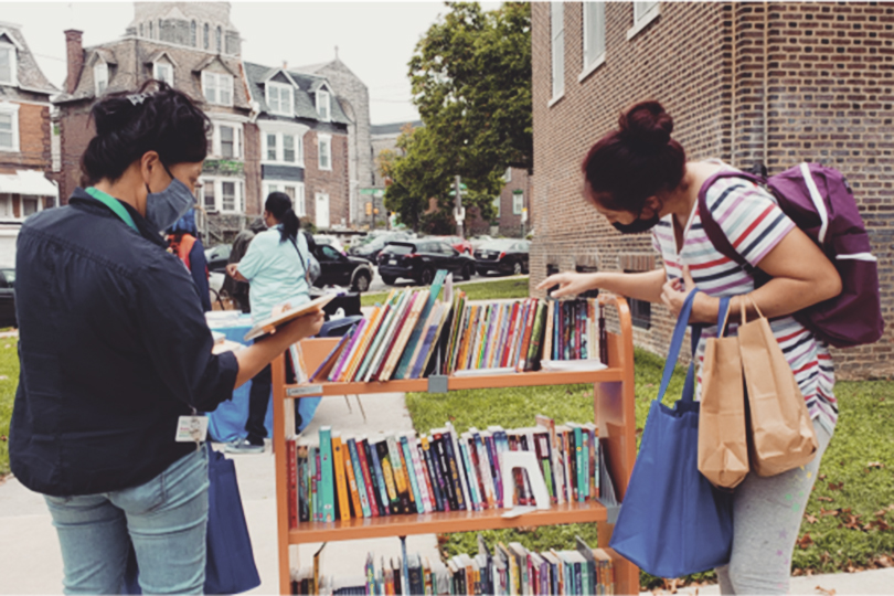 Women looking at books out on the street
