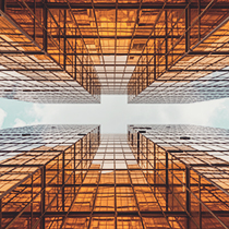 Looking up at two glass buildings