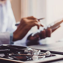 Close up of doctor using cell phone at desk