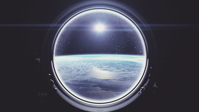 View of Earth and Sun out of porthole on the International Space Station