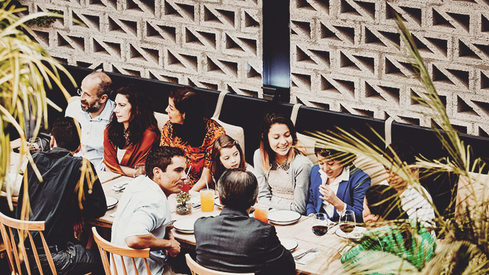 Multi-generational Latino family having dinner in a fancy restaurant.