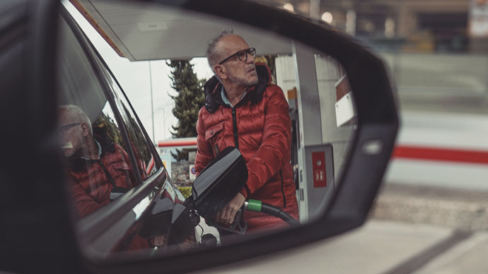 Mature man, sticker shock at gas pump.