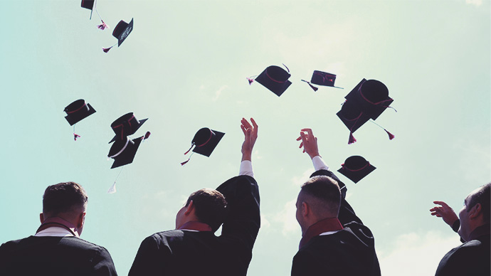 Students throwing caps in the air at graduation