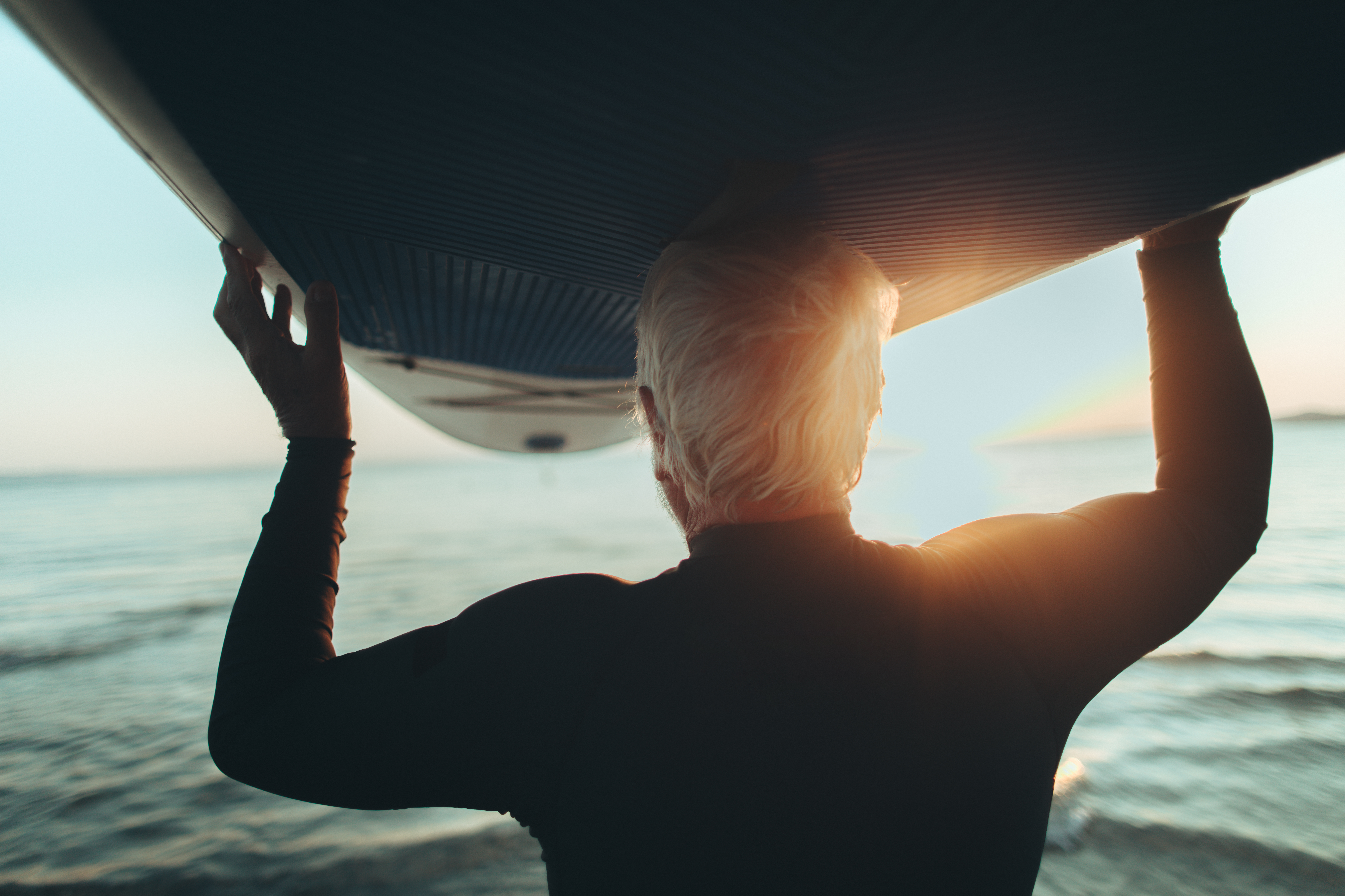 Photo of a senior man who still enjoys surfing and summer activities