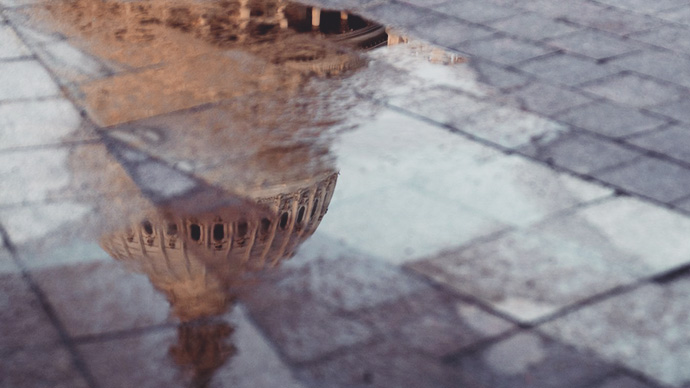 US Capital dome reflected in puddle on brick walkway