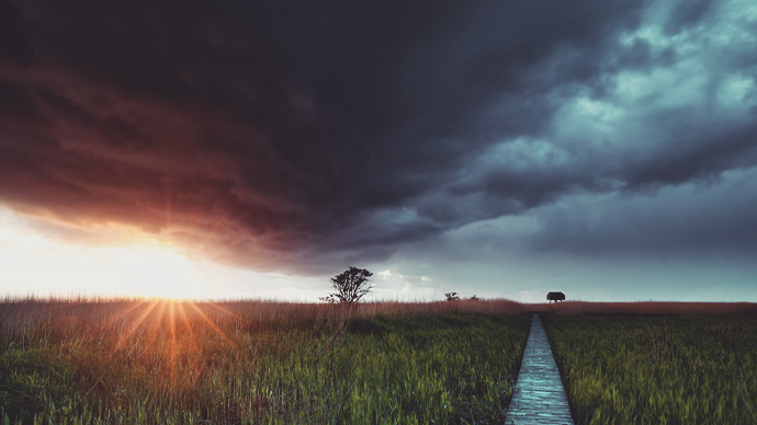 sunshine before rain storm over wooden path
