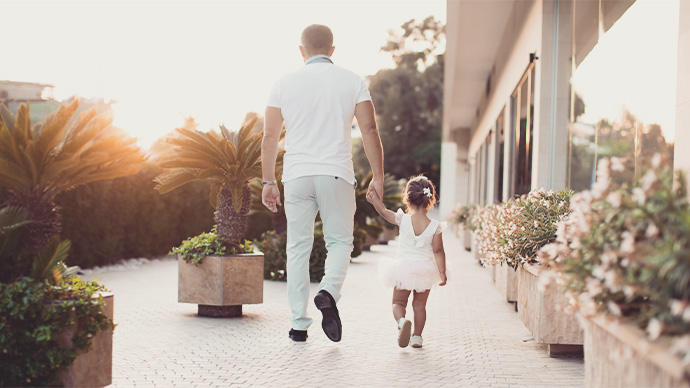 Father and daughter holding hand in hand at sunset, share love. 