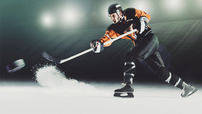 hockey player hitting puck