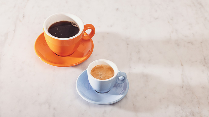 Cup of black coffee and an espresso coffee on a marble counter.