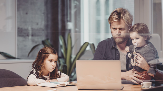 Casual businessman with two daughters working at desk in office