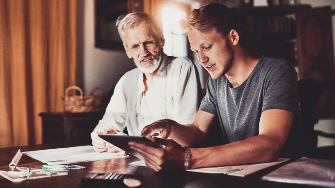 Tablet, investment or retirement with a father and son in their home for savings, budget or finance planning. Accounting, money or insurance with a man helping his senior pensioner parent in the home.