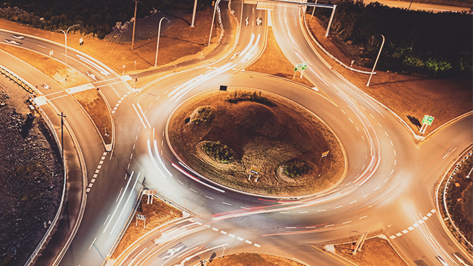 Aerial view of a highway intersection roundabout at night.