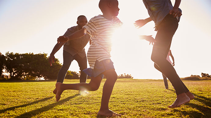 Family playing and running barefoot on grass