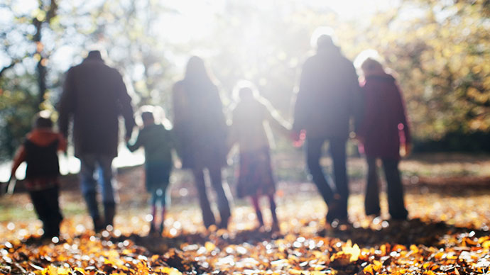 Multi-generational family on a walk during fall season back view