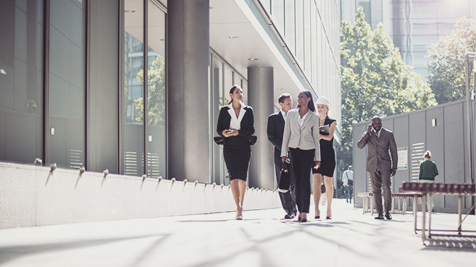 Professionals walking by office building 