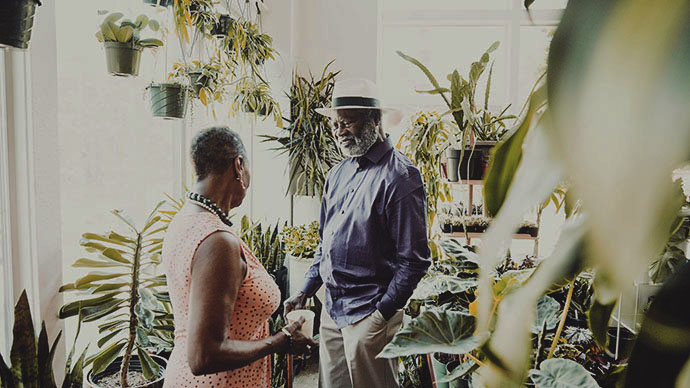 Smiling senior couple in discussion while shopping in plant shop