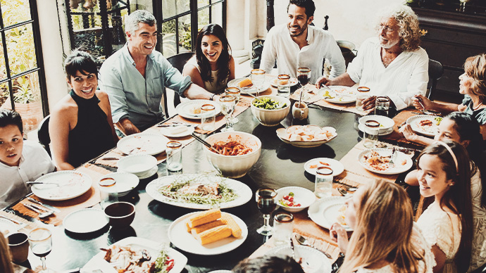 Overhead view of multigenerational family gathered at dining room table for celebration meal