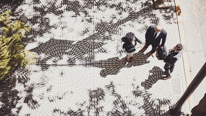 Overhead view of business colleagues in discussion on city sidewalk