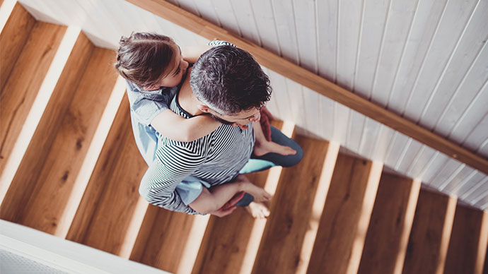 Daughter piggybacking on father down the stairs