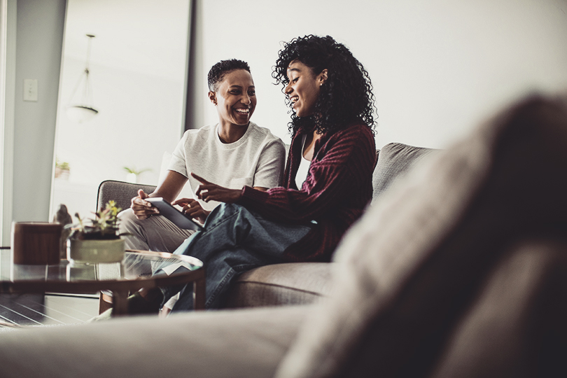 Lesbian couple at home using digital tablet