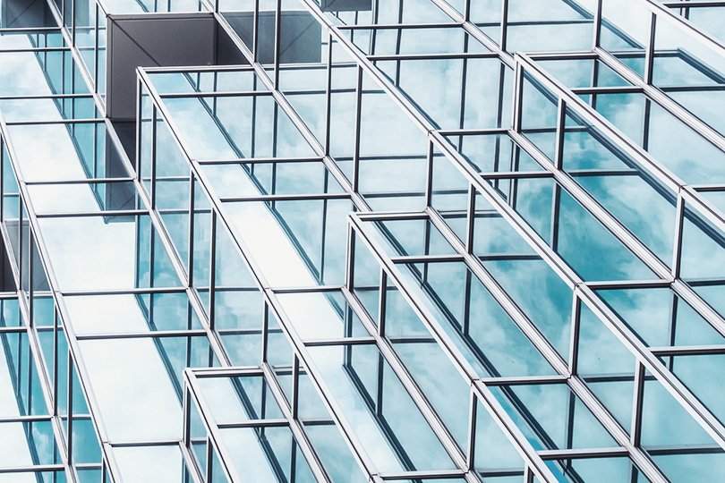 GettyImages-1025417334_Underside panoramic and perspective view to steel blue glass high rise building skyscrapers, business concept of successful industrial architecture