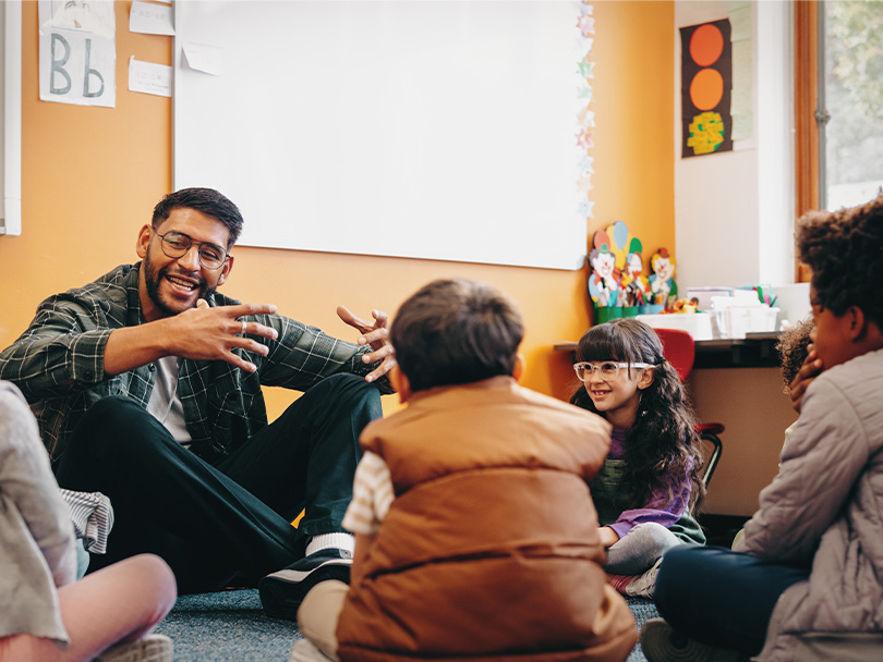 Male educator talking to his students in a classroom