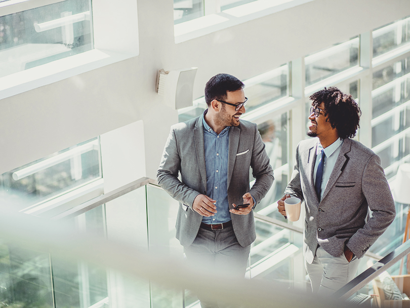 Two business colleagues talking while ascending stairs