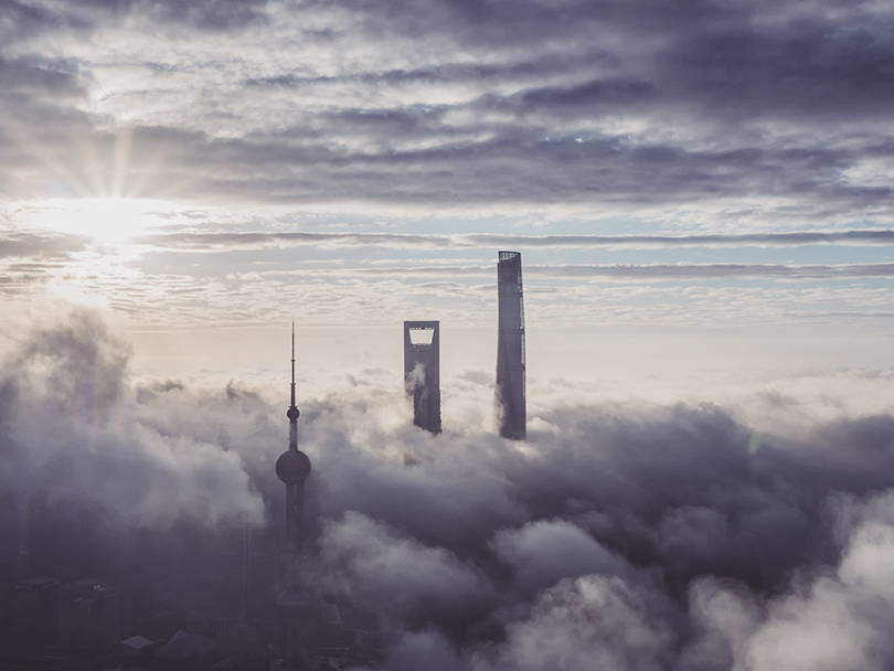 Buildings visible above the clouds