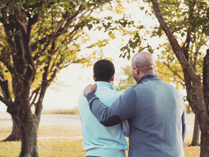 Parenting, father and college age son in park