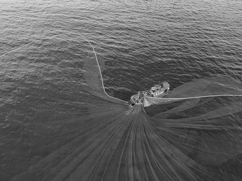 fishermen with net over water