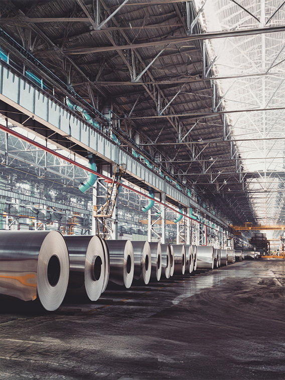 Rolls of sheet metal on factory floor.