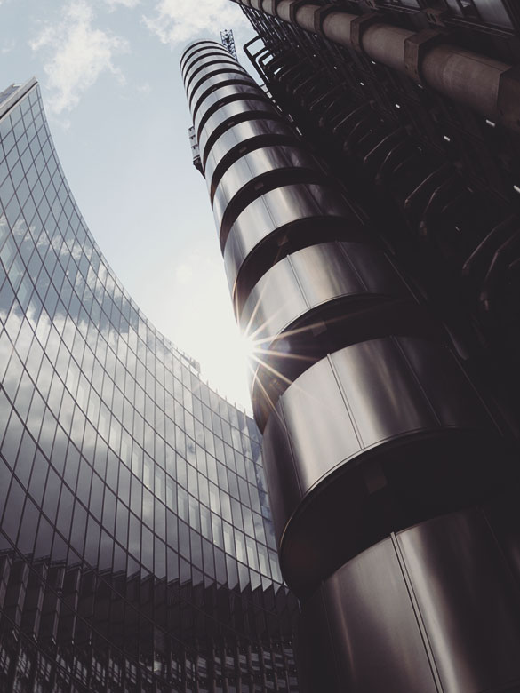 Looking up at glass buildings on a sunny day