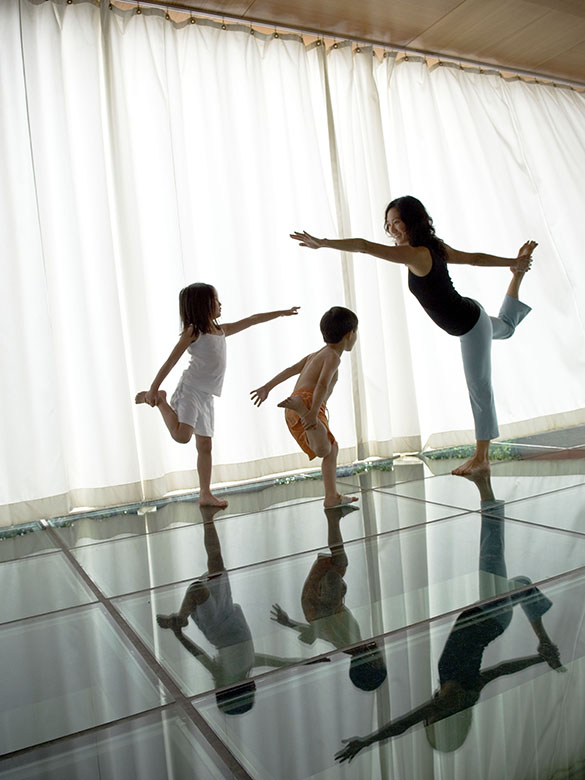 Young mom with children practicing yoga