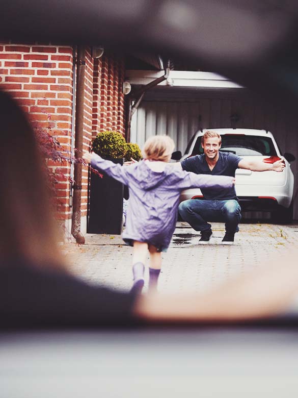little girl running to dad and car
