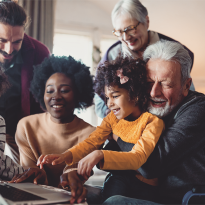 Happy multi-generation family gathering around notebbok and having fun during a video call