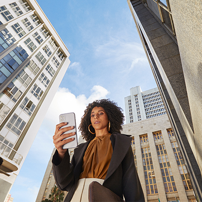 Young business professional on smartphone in urban landscape 